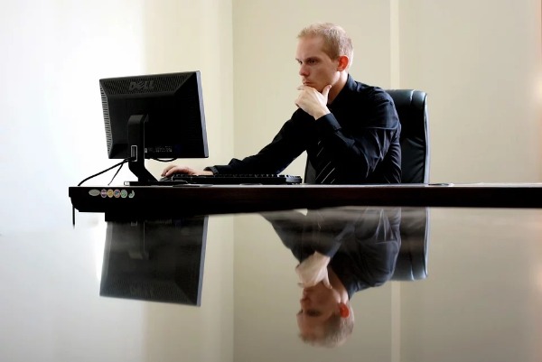 Hombre en su oficina mirando su ordenador