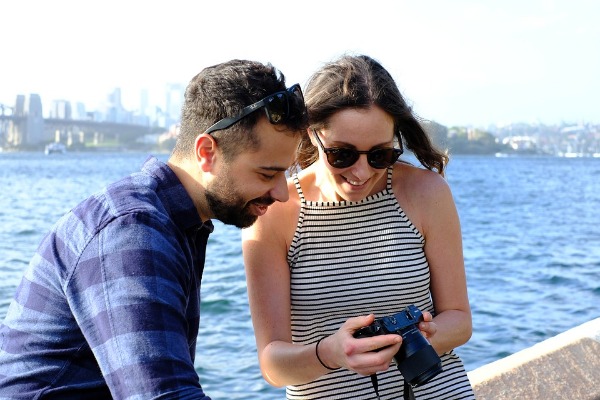 Como romper el hielo con una chica, pareja al aire libre viendo fotos en una cámara